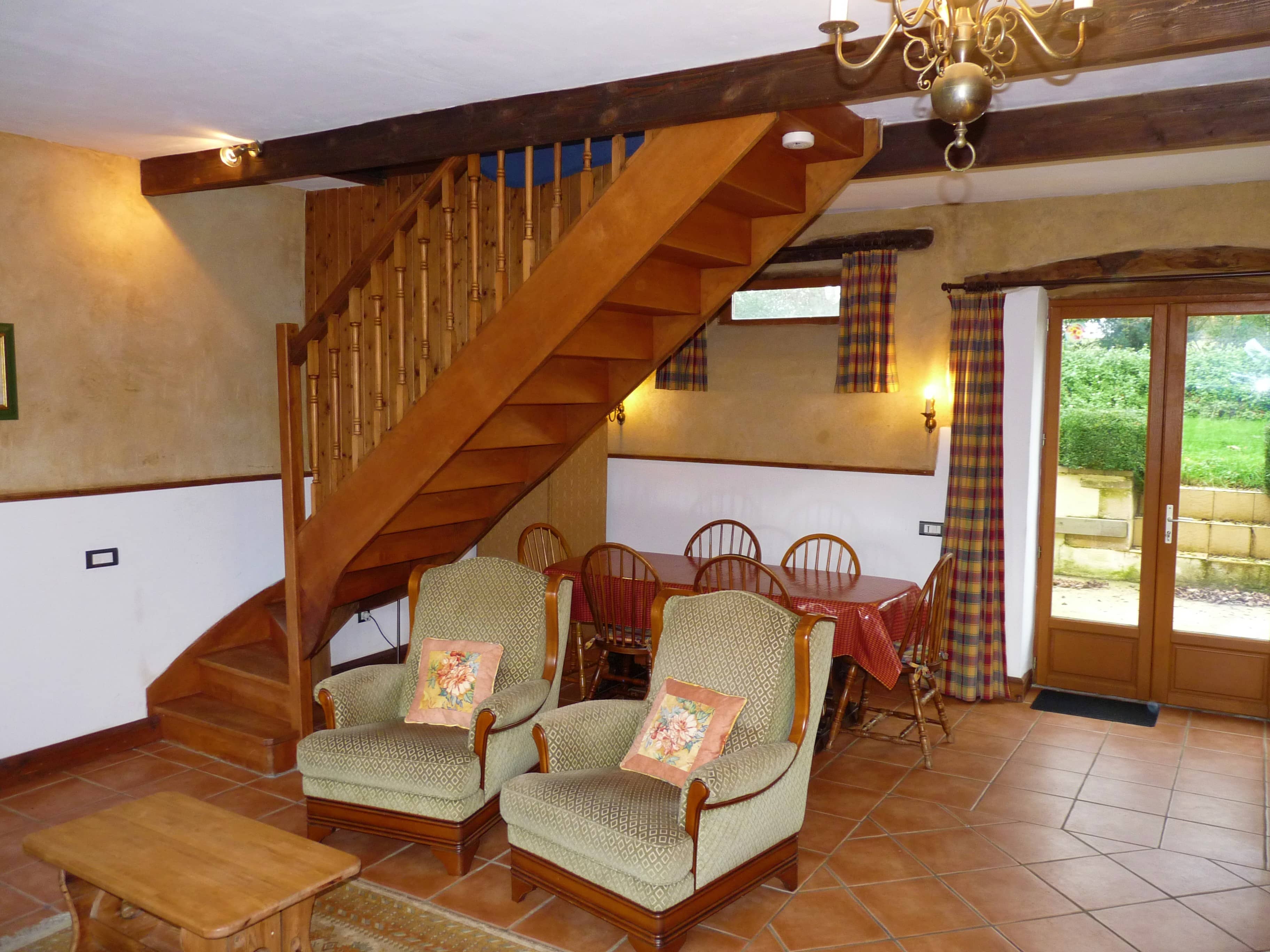 Comfortable living room of La Julerie cottage in Brittany, France, with a view of the surrounding nature and equipped with modern furniture. Ideal for relaxing after a day of sightseeing in Brittany.